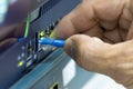 Close-up of a hand plugging a blue ethernet cable into a network switch or router. Concept data connection, internet technology, Royalty Free Stock Photo