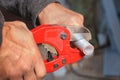 Plumber cuts the ppr pipe using a cutter. Royalty Free Stock Photo