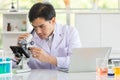 Close up hand. Portrait of Asian man scientist looking in microscope while working on medical research in science laboratory. Royalty Free Stock Photo