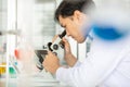 Close up hand. Portrait of Asian man scientist looking in microscope while working on medical research in science laboratory. Royalty Free Stock Photo