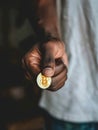 A close-up of a hand presenting a shining Bitcoin coin, symbolizing the digital currency& x27;s tangible impact on the