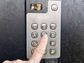 Close-up of hand pressing access code on intercom keypad at building entrance for secure entry Royalty Free Stock Photo