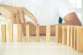 Close-up hand prevent wooden block not falling domino concepts of financial risk management and strategic planning and business Royalty Free Stock Photo