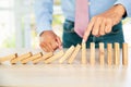 Close-up hand prevent wooden block not falling domino concepts of financial risk management and strategic planning and business Royalty Free Stock Photo