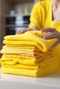 Close up of hand professional chambermaid placing stack of fresh towels in hotel room