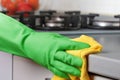Close-up of a hand in a protective glove holding a rag. Cleaning the kitchen Royalty Free Stock Photo