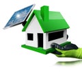 Gloved Hand Holding a Small Model House with Solar Panel on the Rooftop Royalty Free Stock Photo