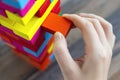 Close up of a hand pulling a colorful jenga block from a big pile. Fun board games concept Royalty Free Stock Photo