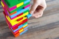 Close up of a hand pulling a colorful  jenga block from a big pile. Fun board games concept Royalty Free Stock Photo
