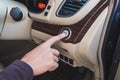 Close-up hand push button in modern car