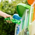 Close up hand put plastic bottle into bin. Royalty Free Stock Photo