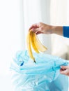 Close up of hand putting food waste to rubbish bag Royalty Free Stock Photo