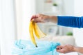 Close up of hand putting food waste to rubbish bag Royalty Free Stock Photo