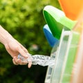 Close up hand putting plastic bottle into bin. Royalty Free Stock Photo