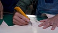 Close-up hand-raising tracing paper which is clear paper, with clear pattern on paper, compared to get same shape size as cut