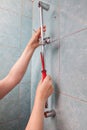 Close-up of hand removed defective bar shower head rail.