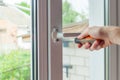 Close-up, hand with a screwdriver tightens the fixing of the window limiter. Royalty Free Stock Photo