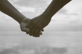 Close up hand of senior couple holding hand together near seaside at the beach,black and white picture color,filtered image Royalty Free Stock Photo