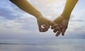 Close up hand of senior couple hook each other's little finger together near seaside at the beach,filtered image Royalty Free Stock Photo