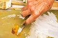 Close up - hand of senior woman mixing oil paint with palette knife Royalty Free Stock Photo