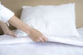 Close up hand set up white bed sheet in hotel room Royalty Free Stock Photo
