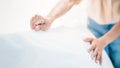 Close up hand set up white bed sheet in hotel room. White bed sheets and pillows. Comfortable soft pillows on the bed Royalty Free Stock Photo