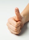 Close up of hand showing thumb with smiley face
