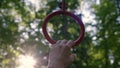 Close up hand of slender athletic woman takes on gymnastic rings. girl in park is doing workout and go in for sport in