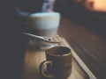 Close up a hand with a spoon pouring sugar in a coffee cup on wooden plate Royalty Free Stock Photo