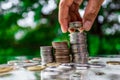 Close up of hand stacking gold coins with green bokeh background ,Business Finance and Money concept,Save money for prepare in the