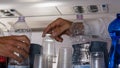 Close up of Hand of a Steward that takes a Plastic Cup during Beverage Distribution on a Flight