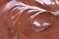 Close up of Hand stirring melted chocolate with spoon. Chocolate surface, melted premium chocolate swirl. Royalty Free Stock Photo