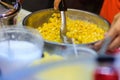 Close up hand of street vendor during cooking for mixed corn but