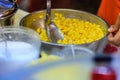 Close up hand of street vendor during cooking for mixed corn but