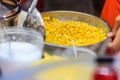 Close up hand of street vendor during cooking for mixed corn but