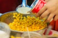 Close up hand of street vendor during cooking for mixed corn but