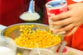 Close up hand of street vendor during cooking for mixed corn but