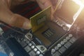 Close up hand of technician putting CPU on the socket of computer motherboard