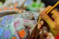 Close up hand of Thai woman artist during painting the masterpiece of Benjarong patterns, the famous thai 5- colored porcelain ce Royalty Free Stock Photo