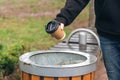 A man throws a paper disposable cup into the trash can in the park. Royalty Free Stock Photo