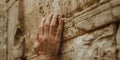 A close-up of a hand touching the ancient stone of a historical monument Royalty Free Stock Photo