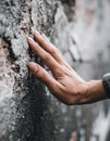 Close Up of a Hand Touching a Rough Grey Stone Wall With Textured Surface Royalty Free Stock Photo