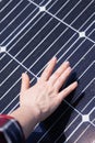 Close-up of a hand touching a solar panel