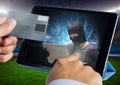 Close up of hand touching a tablet with hacker and holding credit card Royalty Free Stock Photo
