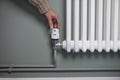 Close Up Of Hand Turning Down Thermostat On Radiator At Home To Save Energy And Money Royalty Free Stock Photo