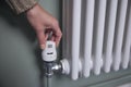 Close Up Of Hand Turning Down Thermostat On Radiator At Home To Save Energy And Money Royalty Free Stock Photo