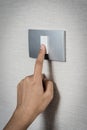 Close up hand turning on or off on grey light switch Royalty Free Stock Photo