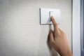 Close up hand turning on or off on grey light switch Royalty Free Stock Photo