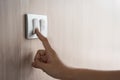 Close up hand turning on or off on grey light switch