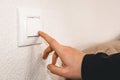 Close-up of a hand turning off a light switch. Royalty Free Stock Photo